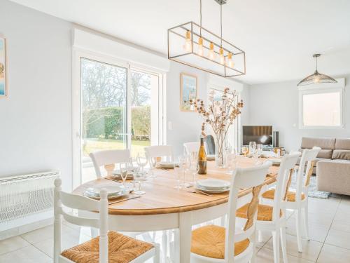 ein Esszimmer mit einem Tisch und weißen Stühlen in der Unterkunft Holiday Home Villa des neuf plages by Interhome in Le Vau Piard