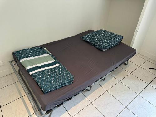 ein Bett mit zwei Kissen auf einem Zimmer in der Unterkunft Shared Room - Chambre Partagée in Marseille