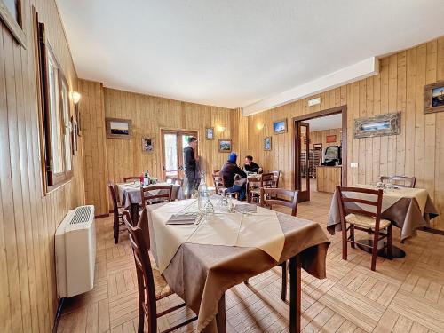 a restaurant with tables and people sitting at tables at Albergo Rifugio La Grande Baita in Cutigliano