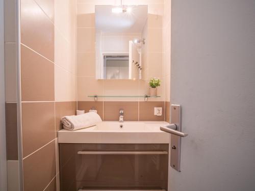 une salle de bain avec un lavabo et un miroir dans l'établissement Apartment Les Jardins de la Plage-13 by Interhome, à Canet