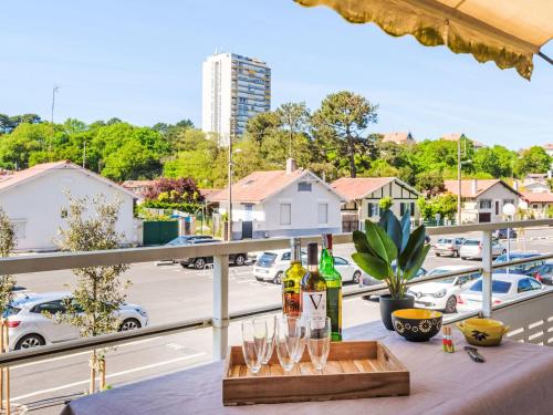 - une table avec des verres à vin et des bouteilles de vin sur le balcon dans l'établissement Apartment Arcachon Marines-3 by Interhome, à Arcachon