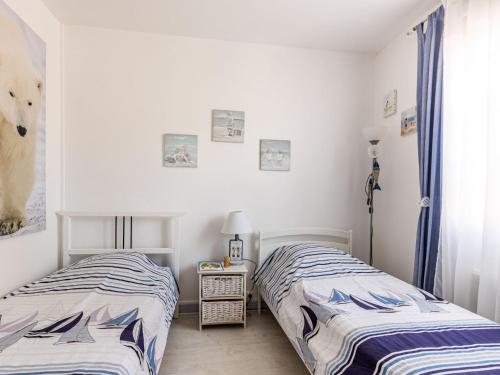 deux lits côte à côte dans une chambre dans l'établissement Holiday Home Mayne by Interhome, à Carcans