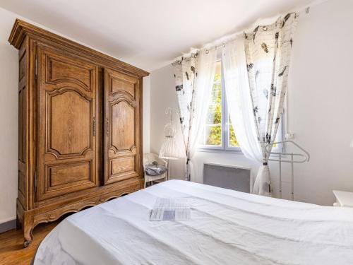 um quarto com um armário de madeira e uma cama em Holiday Home Mayne Pauvre by Interhome em Carcans