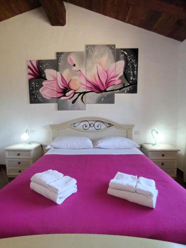 a bedroom with a pink bed with two towels at Villa Olga in Nebida