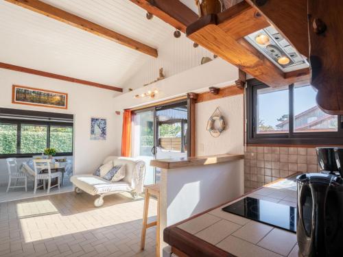 Il dispose d'une cuisine et d'un salon avec des plafonds en bois et des fenêtres. dans l'établissement Holiday Home Les Malgaches by Interhome, à Mimizan