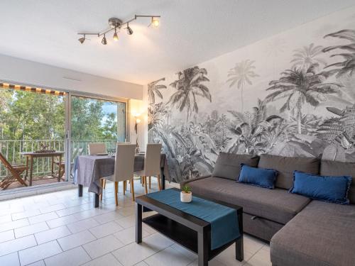 a living room with a couch and a table at Apartment Le Grand Large-2 by Interhome in Hyères