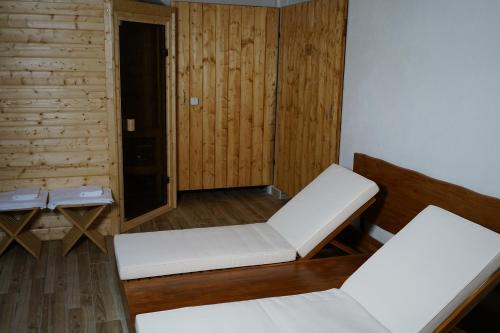 Zimmer mit 2 weißen Stühlen und Holzwänden in der Unterkunft Patio zen in Nîmes