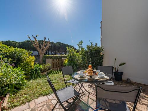 un patio avec une table et des chaises dans une cour dans l'établissement Apartment Marina Village-7 by Interhome, à Saint-Cyprien