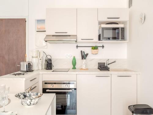 una cocina blanca con armarios y electrodomésticos blancos en Apartment Le Manon by Interhome, en Dinard