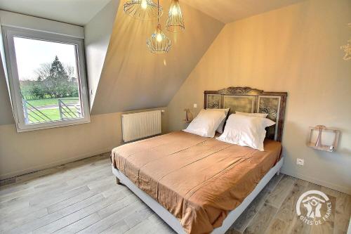 a bedroom with a large bed with a large window at Le petit duc in Langast