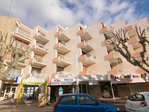 un bâtiment avec des voitures garées devant lui dans l'établissement Apartment Les Hesperides-3 by Interhome, à Cavalaire-sur-Mer