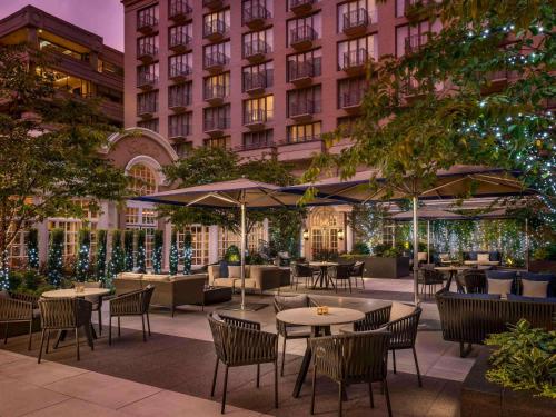 un patio al aire libre con mesas y sillas y un edificio en The Fairmont Washington DC, en Washington