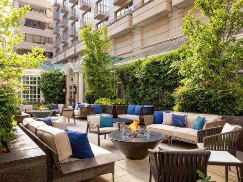 een patio met banken en stoelen en een vuurplaats bij The Fairmont Washington DC in Washington