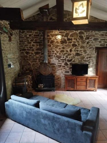 - un canapé bleu dans une chambre avec un mur en briques dans l'établissement Maison de charme Hautpoul, à Mazamet