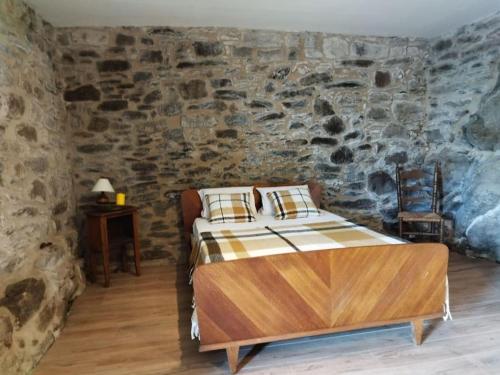 een slaapkamer met een bed in een stenen muur bij Maison de charme Hautpoul in Mazamet