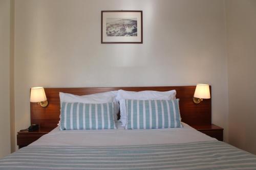 um quarto com uma cama com duas almofadas azuis e brancas em Hotel Santo Antonio Da Baia em São Martinho do Porto