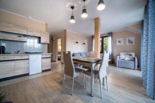 cocina y comedor con mesa y sillas en Ceramika Bolesławiec Apartament, en Bolesławiec