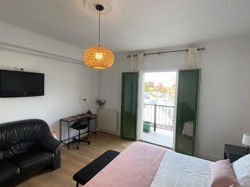 a bedroom with a bed and a couch and a television at Campo de la Compañía in Monforte de Lemos