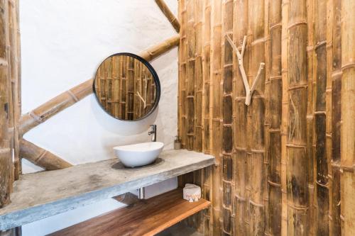 a bathroom with a sink and a mirror on a wooden wall at San Augustin - Standard Double Room - Colombia in San Agustín