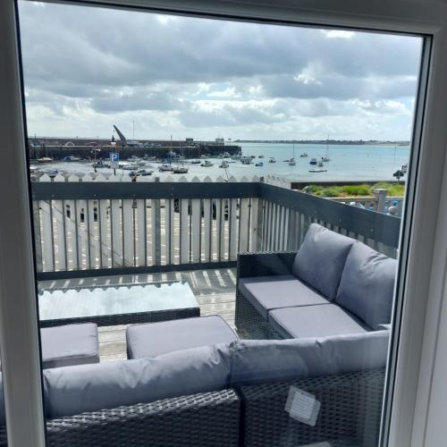 a balcony with a couch and a view of the ocean at Gorey retreat main house in Gorey