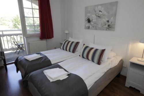 a bedroom with two beds and a balcony at Rasta Mariestad in Mariestad