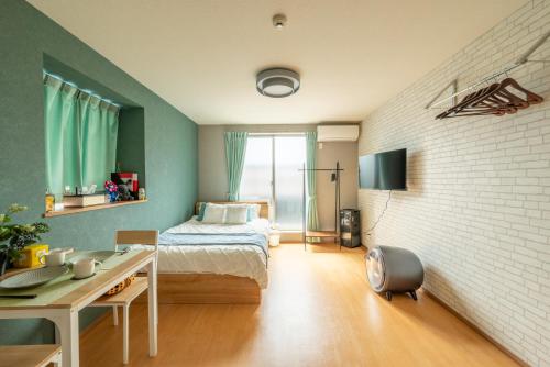 a bedroom with a bed and a desk in it at 梅田まで電車で5分 1フロア貸切 駅徒歩3分 2024年フルリフォーム 建物3階 in Osaka