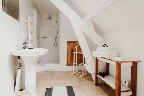 a white bathroom with a sink and a toilet at Les Perséides in Lézignan