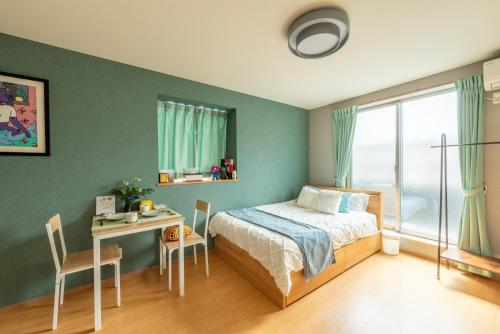 a bedroom with a bed and a table and a desk at 梅田まで電車で5分 1フロア貸切 駅徒歩3分 2024年フルリフォーム 建物3階 in Osaka