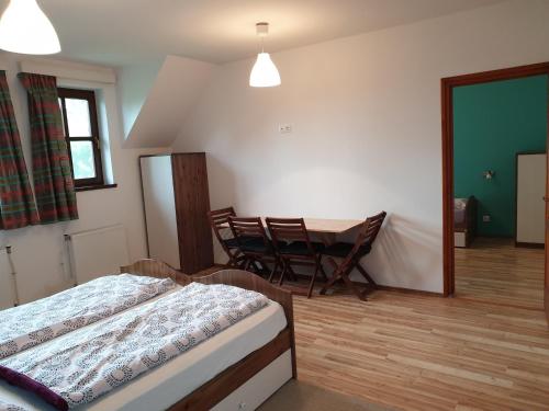 1 dormitorio con 1 cama, mesa y sillas en Velocipéd Vendégház, en Balatonudvari