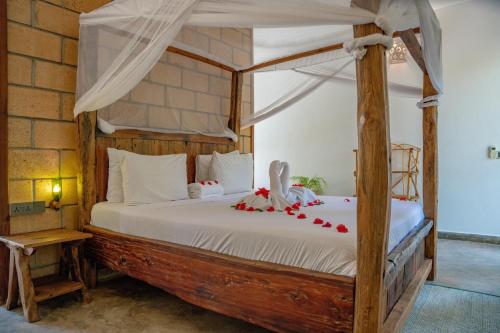 1 dormitorio con cama con dosel y arcos rojos. en Maisha Nungwi en Nungwi