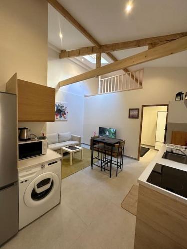 une cuisine avec un lave-linge et une table dans l'établissement Appartement lumineux et clim, à Beausoleil