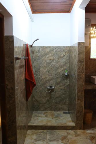 een douche met een glazen deur in de badkamer bij Czech House in Tangalle