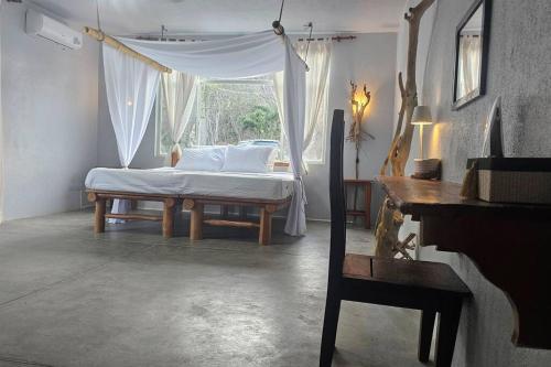 - une chambre avec un lit à baldaquin et une fenêtre dans l'établissement Villa Ballena Art Project, à La Cruz