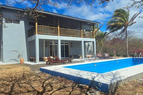 une maison avec une piscine en face de celle-ci dans l'établissement Villa Ballena Art Project, à La Cruz