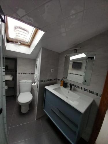 a bathroom with a toilet and a sink and a mirror at La buhardillita in Laredo