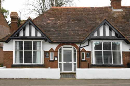 een huis met een zwart-wit dak bij The Almshouse Suites in Woburn Sands