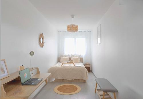 ein Schlafzimmer mit einem Bett und einem Schreibtisch mit einem Laptop in der Unterkunft LOFT COZY 77 CONFORT Terrasse - Free Parking - Wifi - 3 CH et 2 SDB - Aéroport CDG - Disneyland Paris in Annet-sur-Marne