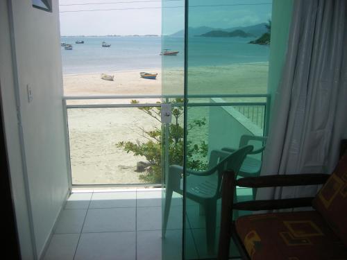 a room with a view of the beach from a window at Solar Dona Maria in Pinheira
