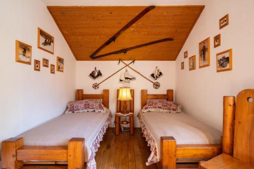 two twin beds in a room with wooden ceilings at Fortuna Eco - Boutique Hotel in Băile Tuşnad