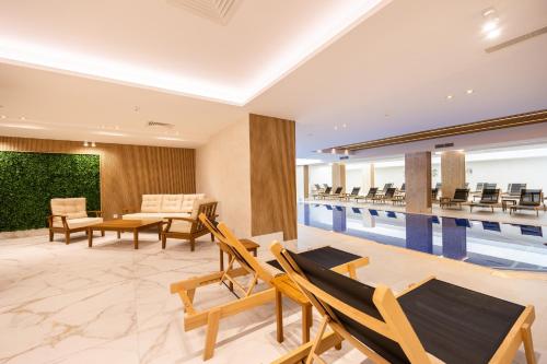 a pool room with chairs and a swimming pool at Admiral Hotel - Ultra All Inclusive & Private Beach in Golden Sands