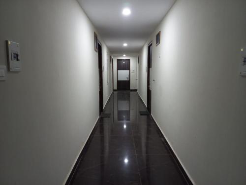 a long hallway with white walls and a tile floor at HOTEL TIRATH in Rishīkesh