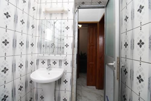 ein Bad mit einem Waschbecken und einem Spiegel in der Unterkunft Appartement meublé à Douala, Bonamoussadi in Douala