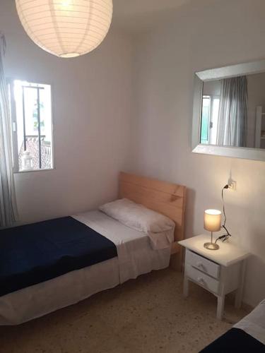 a bedroom with a bed and a table with a lamp at Casa en Punta Del Moral in Isla del Moral