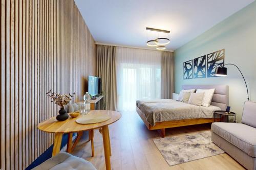 1 dormitorio con cama, mesa y sofá en 3unity Apartman Kamence, en Kysucké Nové Mesto