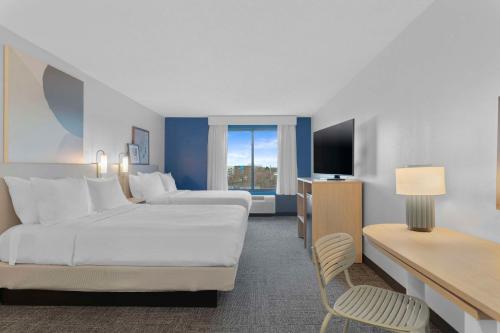 Habitación de hotel con 2 camas y TV en Spark By Hilton Greensboro en Greensboro