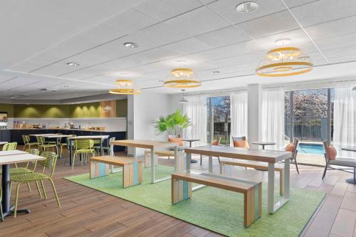 a restaurant with tables and chairs and a pool at Spark By Hilton Greensboro in Greensboro