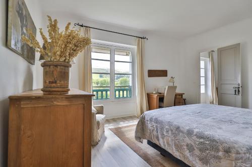 a bedroom with a bed and a large window at Belle maison basque avec grande Piscine chauffée (5x10m2) in Saint-Pée-sur-Nivelle