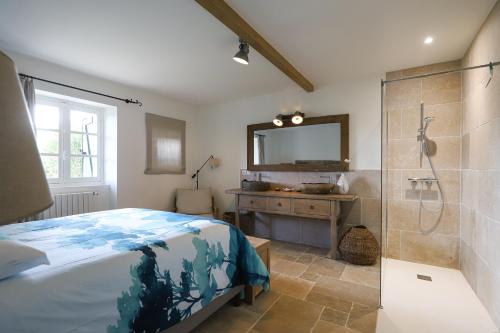 una camera da letto con doccia, letto e specchio di Belle maison basque avec grande Piscine chauffée (5x10m2) a Saint-Pée-sur-Nivelle