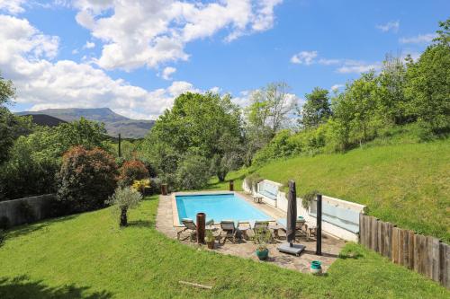 une cour arrière avec une piscine et une colline dans l'établissement Belle maison basque avec grande Piscine chauffée (5x10m2), à Saint-Pée-sur-Nivelle