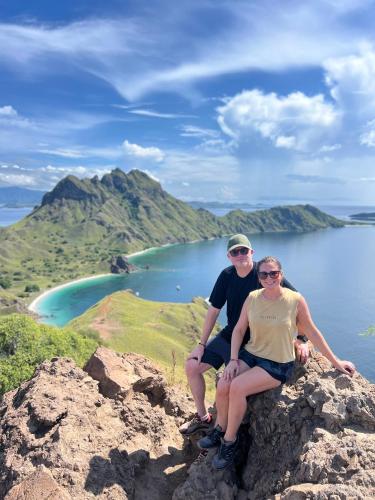 a man and a woman sitting on top of a mountain at Jhuna Komodo Homestay in Komodo